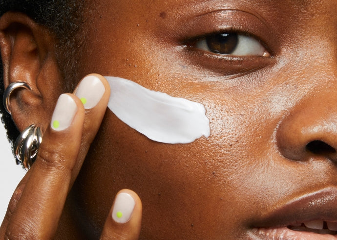 Model wears Milk Makeup Hydro Grip Primer on a white backround.