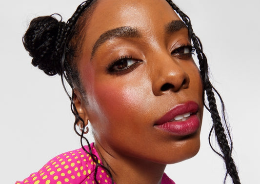 Model wears Milk Makeup Cooling Water Jelly Tint on cheeks against a white background