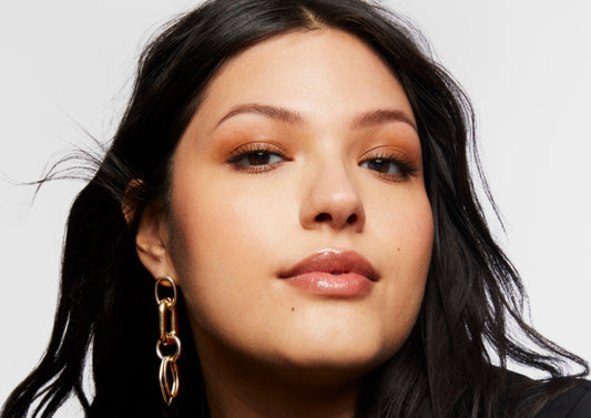 Portrait of Milk Makeup model Vanessa with a smoky warm neutral eye makeup on a white background