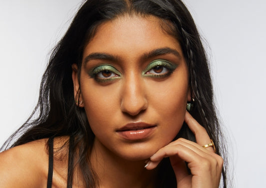 Portrait of Milk Makeup model Lizzy with smoky green eyeshadow on a white background