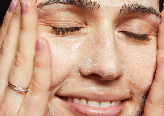  Close-up of model washing her face using Vegan Milk Cleanser